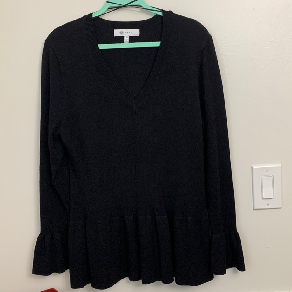 Black V neck Fever sweater with flaired sleeves and around hips.